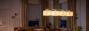 Modern LED pendant light with multiple fabric shades illuminates a cosy living room, showcasing energy-efficient and stylish home lighting solutions for ambient evening comfort.