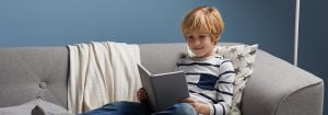 "Child reading under soft LED light, showcasing comfortable illumination for evening storytimes and promoting healthy sleep habits in cosy bedroom setting."