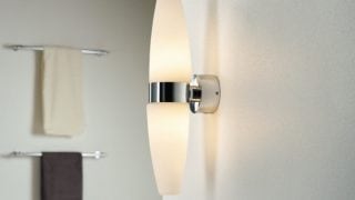 Modern bathroom featuring sleek LED wall light, illuminating minimalist decor and enhancing spa-like ambiance.